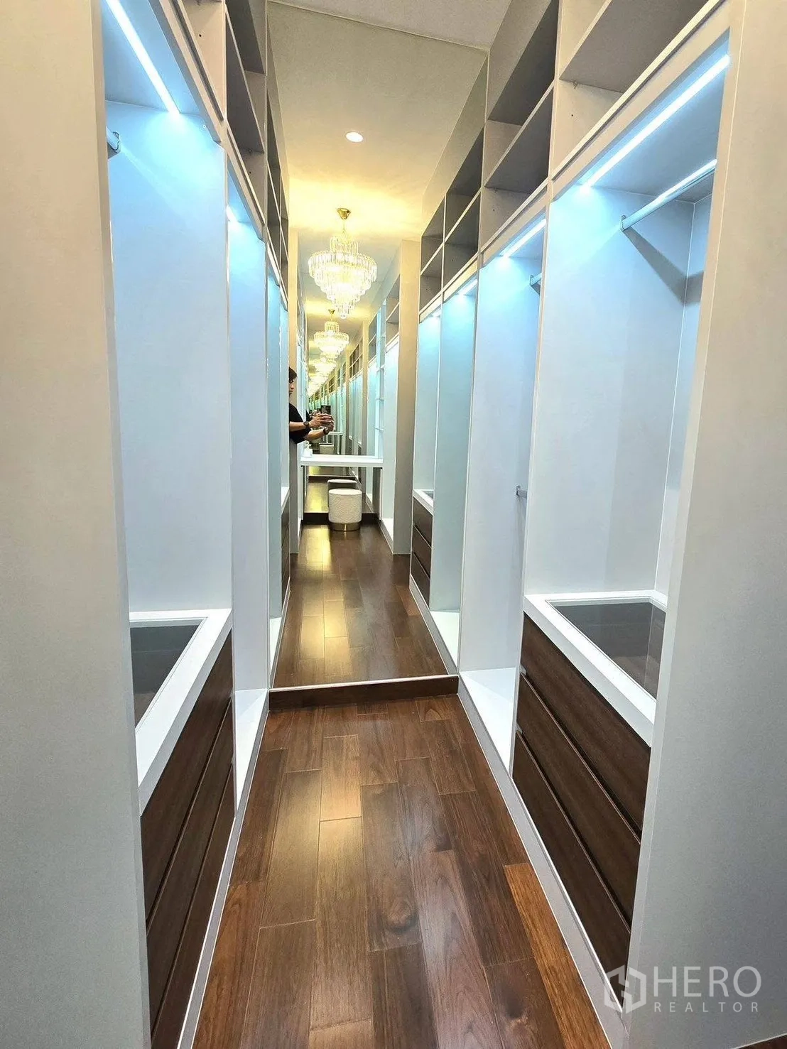 Detached House for rent or sale in Bang Phli, Samut Prakan - Walk-in closet with built-in shelves, mirrored wall, chandelier and warm wood flooring.