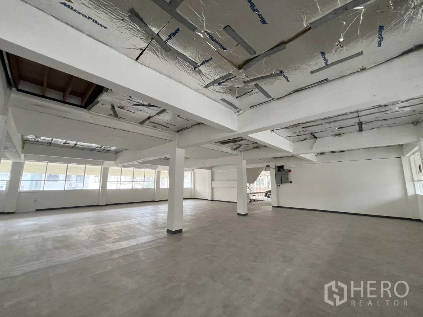 Office Space for rent in Watthana, Bangkok - Open workspace with electrical panel, long window line, and exposed ceiling insulation.