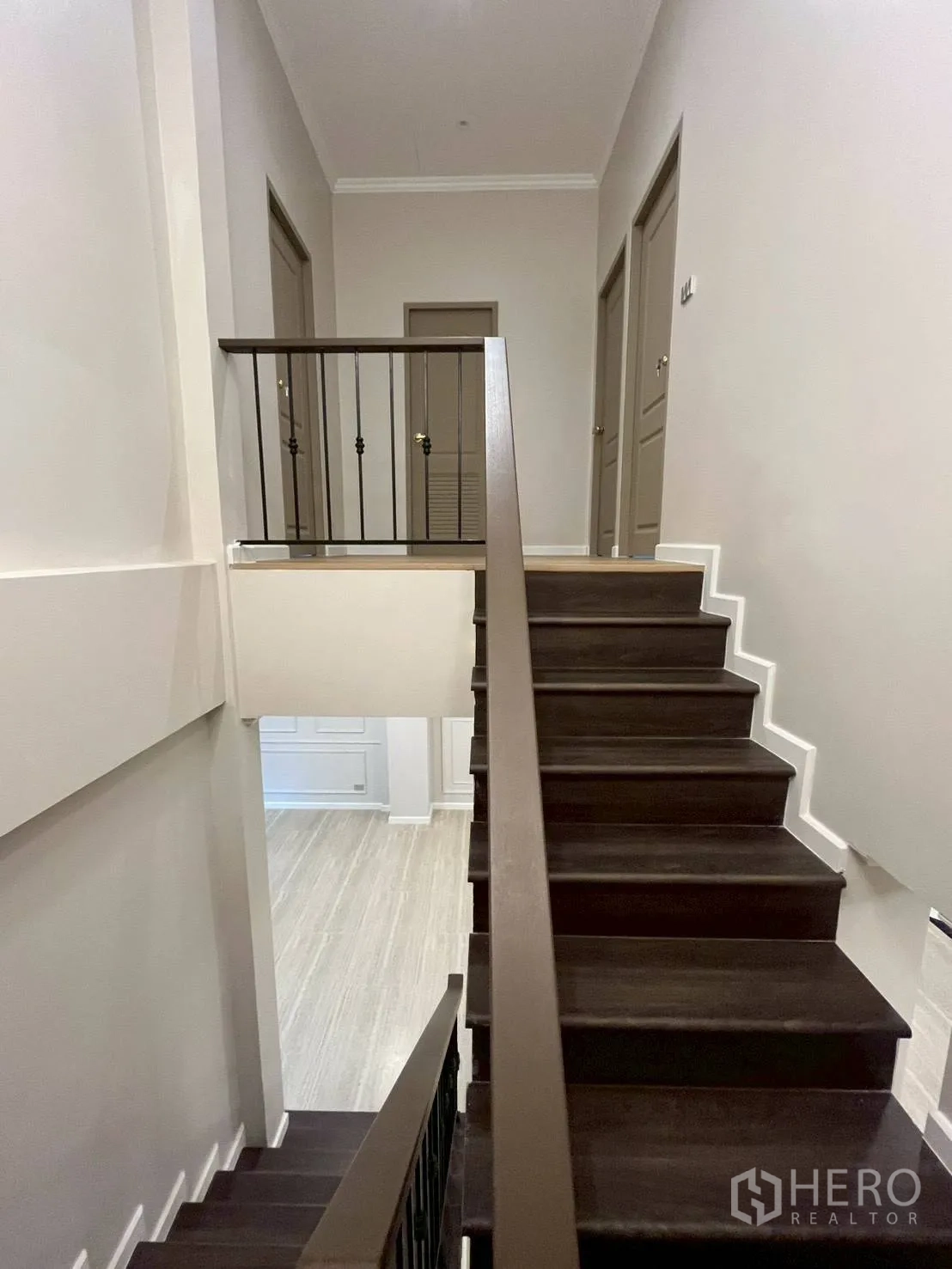 Townhouse for rent in Khlong Toei, Bangkok - Interior staircase with dark wood steps and metal railings.