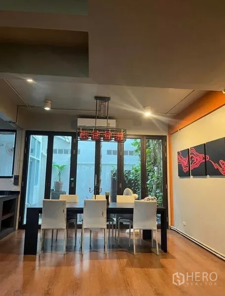 Townhouse for rent in Phaya Thai, Bangkok - Dining room for six with pendant lighting and glass doors opening to a green courtyard.
