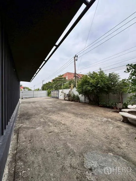 Warehouse for rent in Prawet, Bangkok - Wide concrete yard and gate providing truck access beside the warehouse.