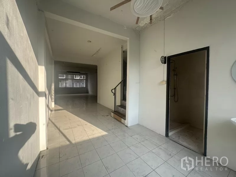 Shophouse for rent in Khlong Toei, Bangkok - Ground floor area with doorway to shower room and internal staircase.