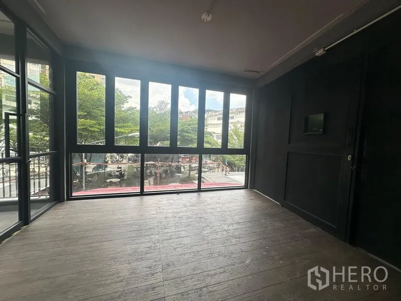 Retail Space for rent - Corner room with floor-to-ceiling windows overlooking a tree-lined plaza near BTS Phra Khanong.