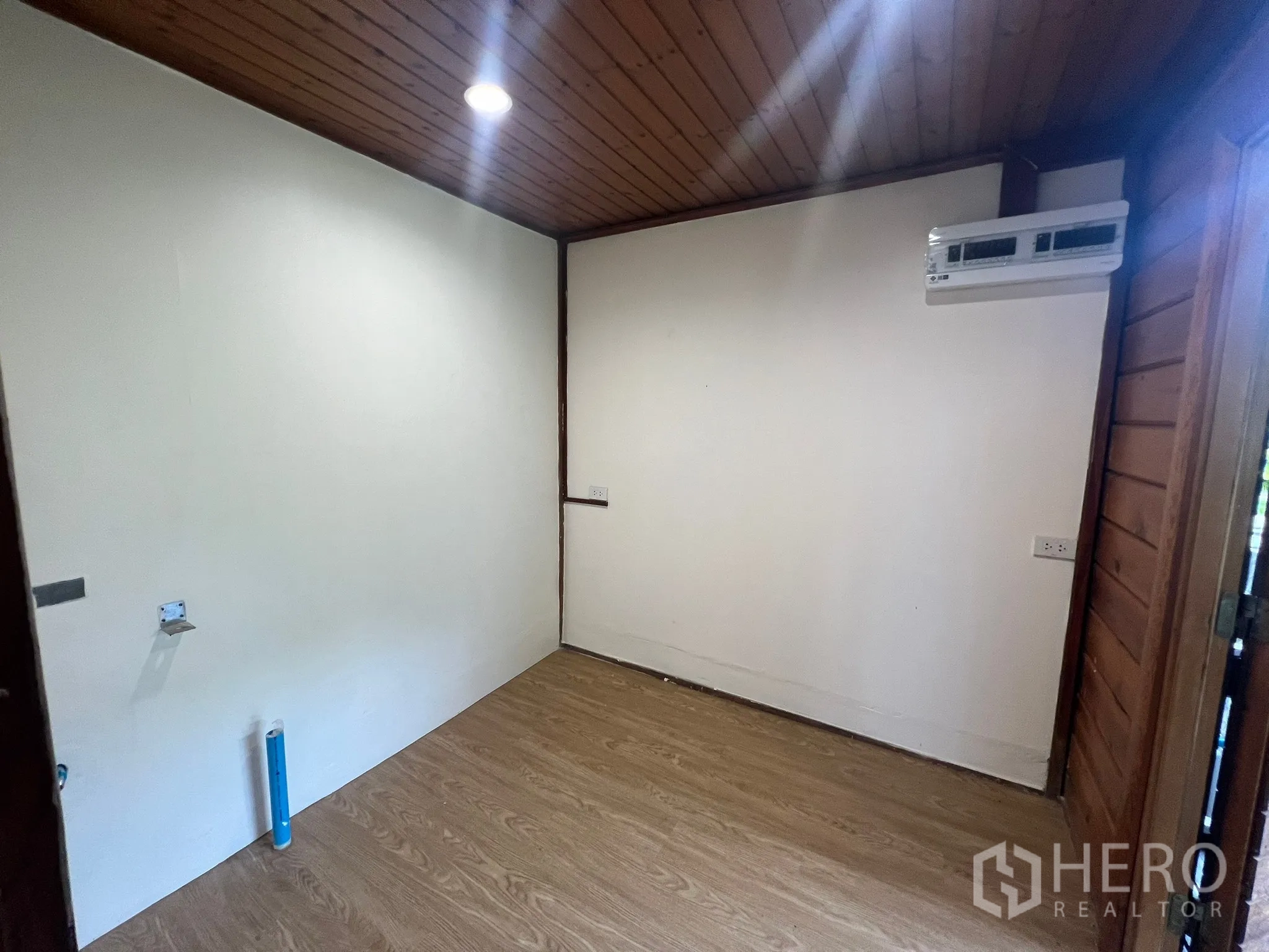 Home Office for rent in Suan Luang, Bangkok - Compact office room with a white feature wall, wood ceiling and air conditioning.