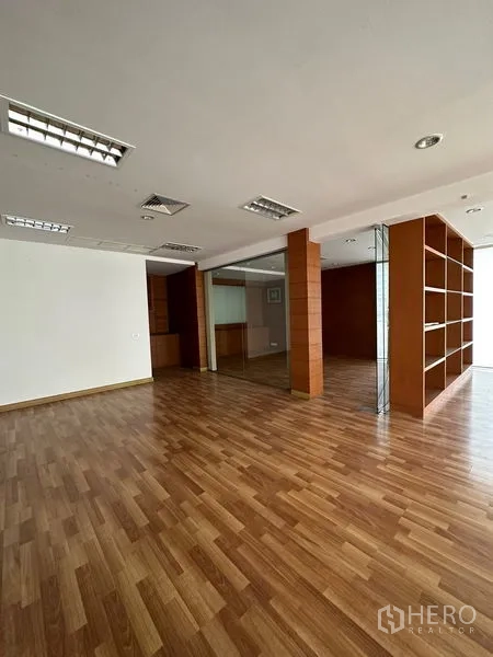 Office Space for rent in Pathum Wan, Bangkok - Open office area with wood flooring, built-in shelving and glass dividers.