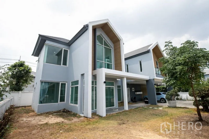Detached House for rent or sale in Lam Luk Ka, Pathum Thani - Rear exterior of the house with a covered terrace and private yard.