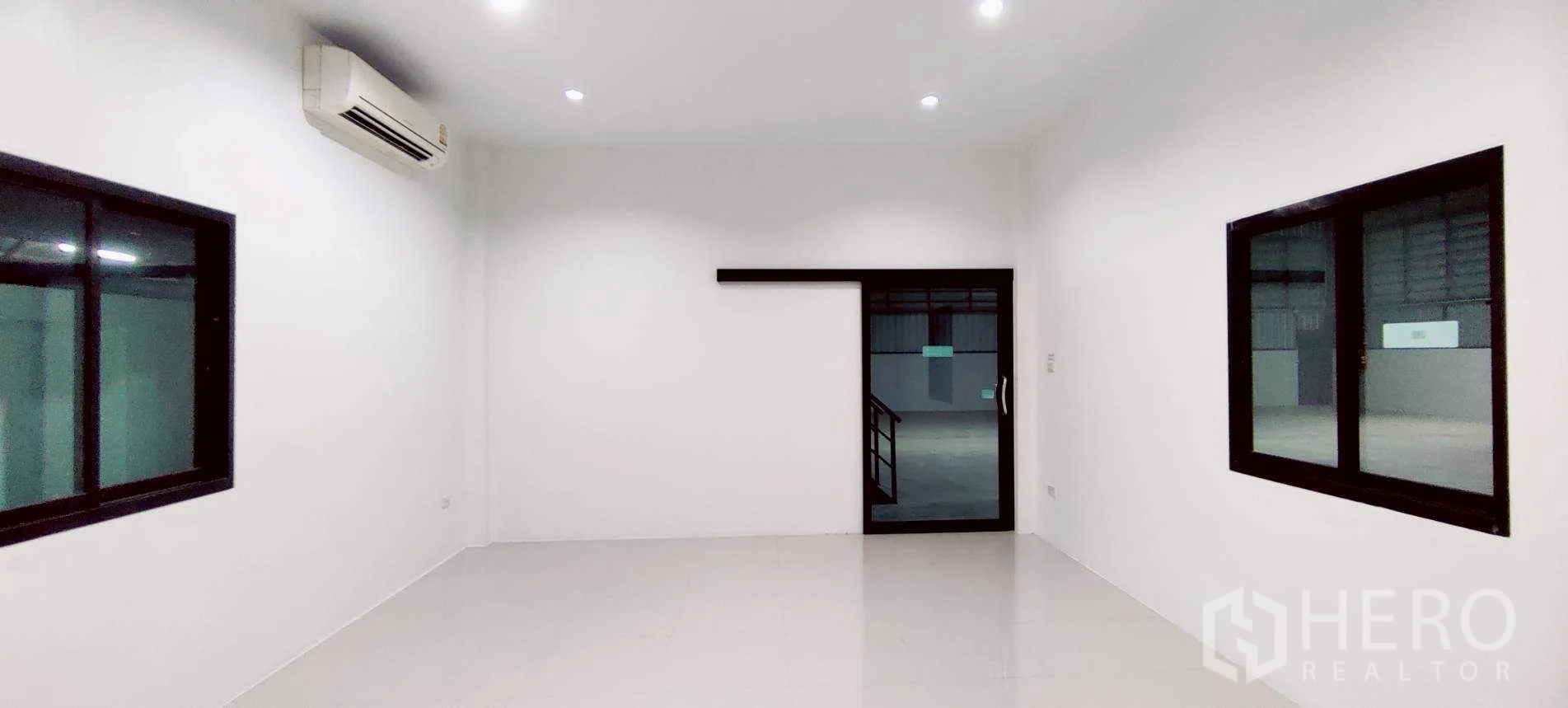Warehouse for rent in Lam Luk Ka, Pathum Thani - Air‑conditioned office room with white walls and black‑framed windows.