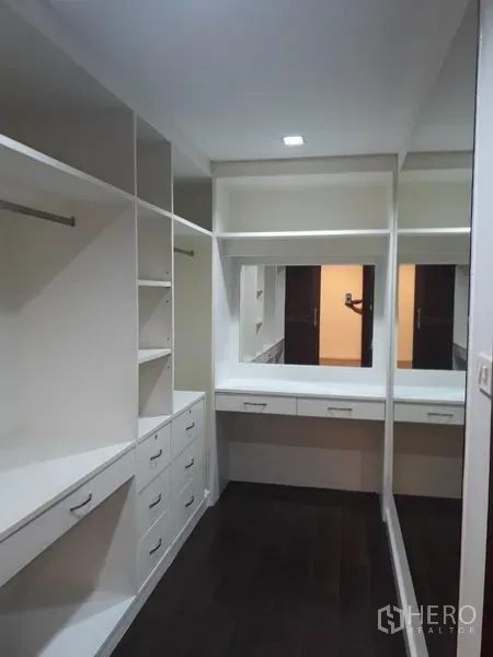 Detached House for rent in Watthana, Bangkok - Walk-in closet with white built-in shelves, drawers and dressing mirror