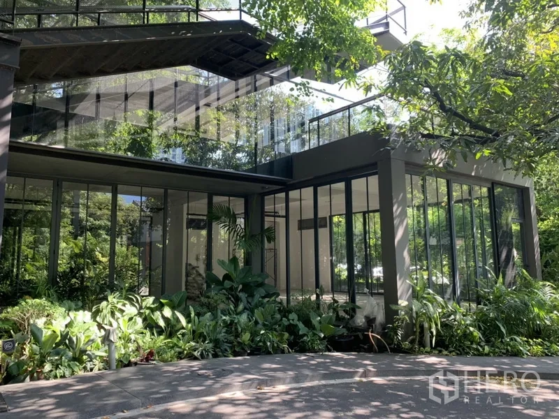 办公空间 出租在Khlong Toei, Bangkok - 两层玻璃立面的办公楼，环绕花园与露台