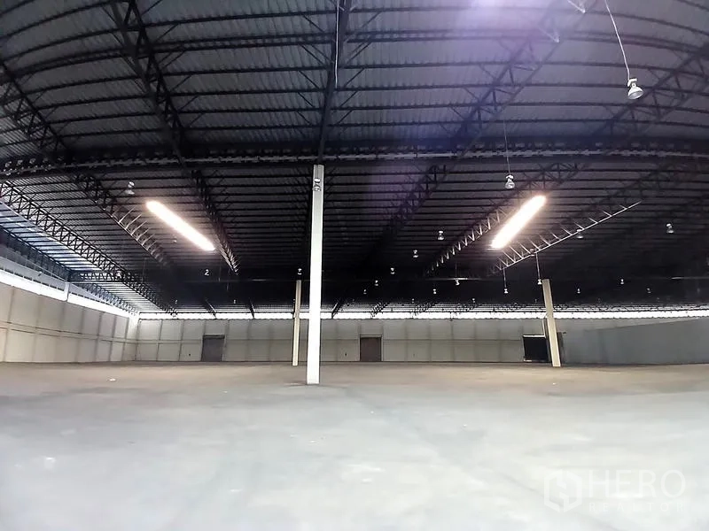 货栈 出租在Bang Pakong, Chachoengsao - 开阔仓库区，钢桁架屋顶，明亮灯带与多扇装卸门。