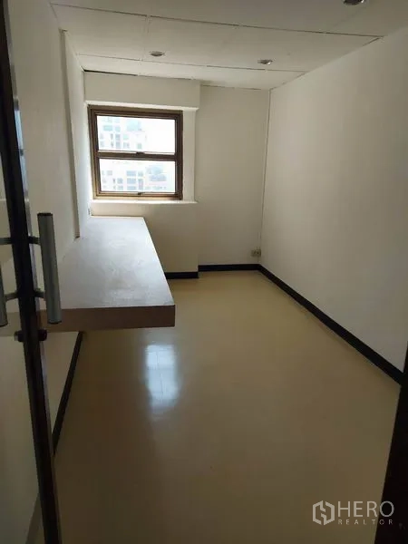 Office Space for rent in Pathum Wan, Bangkok - Compact private office with window and built-in countertop desk.