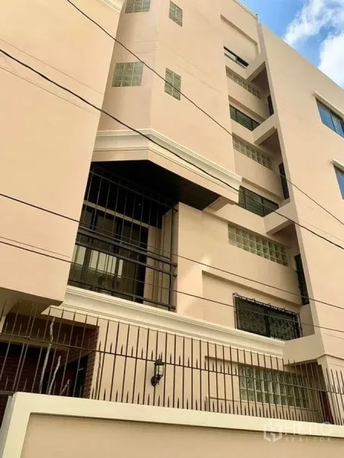 Home Office for rent - Multi-storey building exterior with security grilles and a pastel facade.
