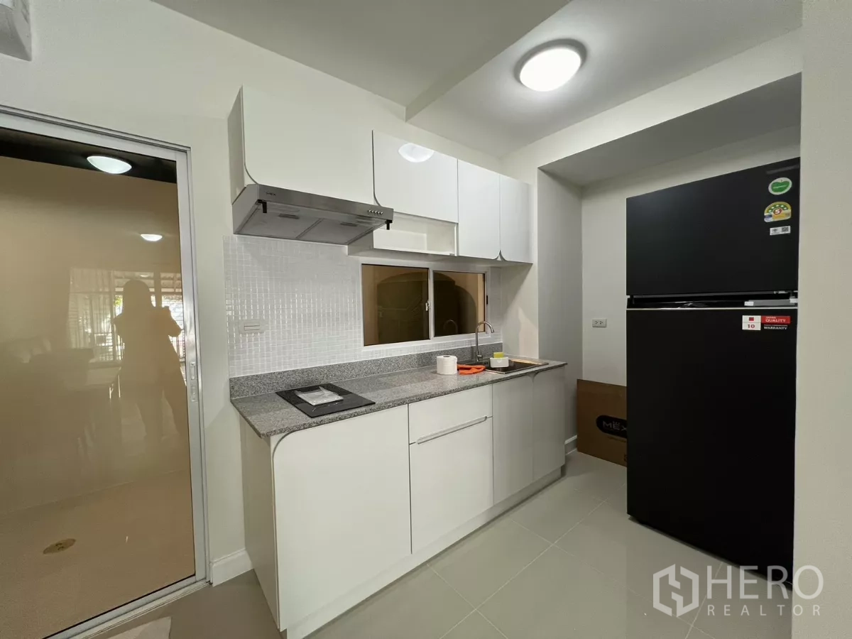 Townhouse for rent in Bang Kapi, Bangkok - Close view of white cabinets, backsplash and sink in the kitchen.
