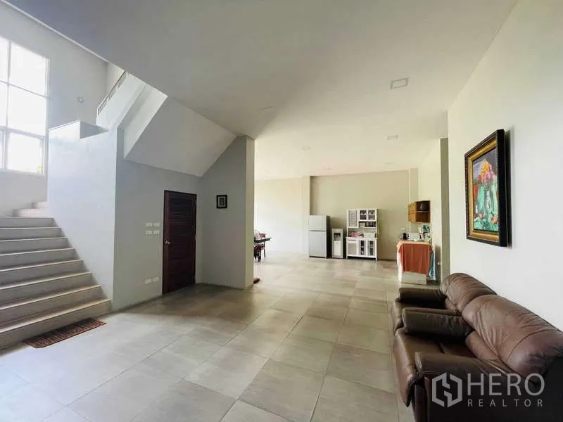 Factory for sale in Krathum Baen, Samut Sakhon - Ground-floor lobby with staircase, sofa seating, and a pantry area.