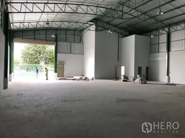 Factory for rent or sale in Khlong Luang, Pathum Thani - Warehouse bay with a large roller shutter entry, internal office block, and open loading space.