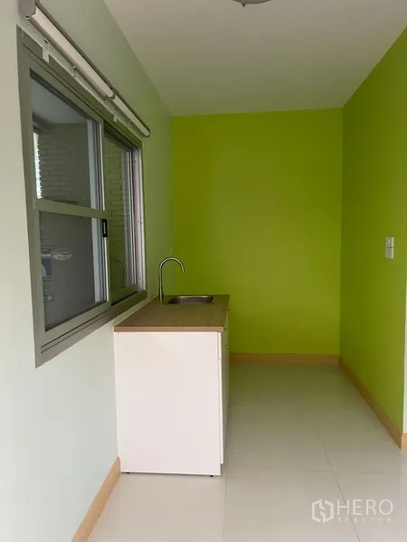 Townhouse for rent in Khlong Toei, Bangkok - Compact pantry kitchenette with sink, sliding window and green feature wall