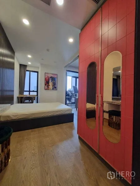 Condominium for rent in Bang Rak, Bangkok - Bedroom with red wardrobe, wood floors and large windows.