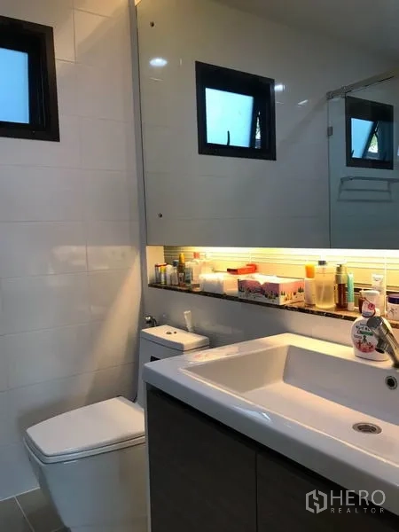 Detached House for rent in Bang Kapi, Bangkok - Bathroom with illuminated mirror, sink vanity and toilet.