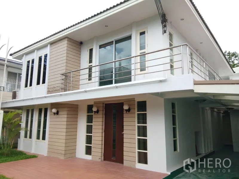 Detached House for rent in Watthana, Bangkok - Two-storey detached house exterior in Watthana, Bangkok with balcony, large windows and tiled front patio.