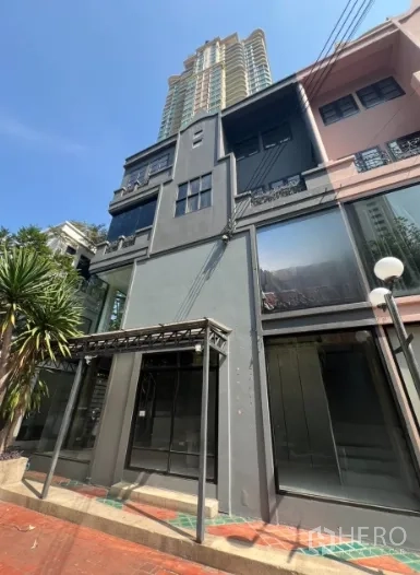 อาคารพาณิชย์ ให้เช่าในWatthana, Bangkok - อาคารพาณิชย์หลายชั้นสไตล์โมเดิร์นบนสุขุมวิท หน้ากระจกขนาดใหญ่และตึกสูงด้านหลัง.