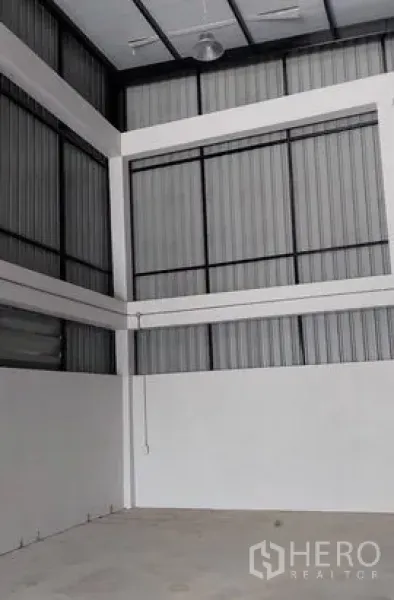 Warehouse for rent in Lam Luk Ka, Pathum Thani - Warehouse interior with high-clearance ceiling, steel wall panels and ventilation windows.