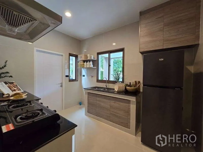 Detached House for rent in Bang Kapi, Bangkok - Bright Thai kitchen with window over sink and wood cabinetry.