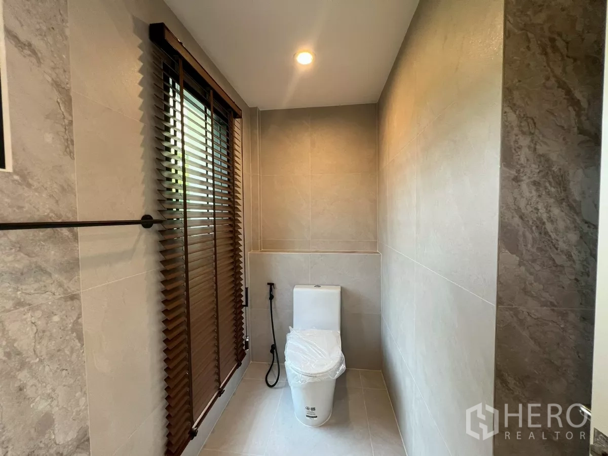 Detached House for rent in Suan Luang, Bangkok - Guest washroom with window blinds, modern toilet, and neutral tiles.