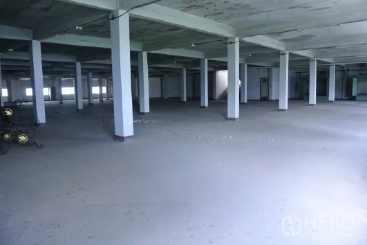 Factory for sale in Bang Phli, Samut Prakan - Expansive warehouse floor with multiple columns and high ceiling.