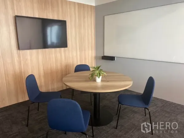 Office Space for rent in Pathum Wan, Bangkok - Small meeting room with round table, four blue chairs, wall-mounted TV and whiteboard.