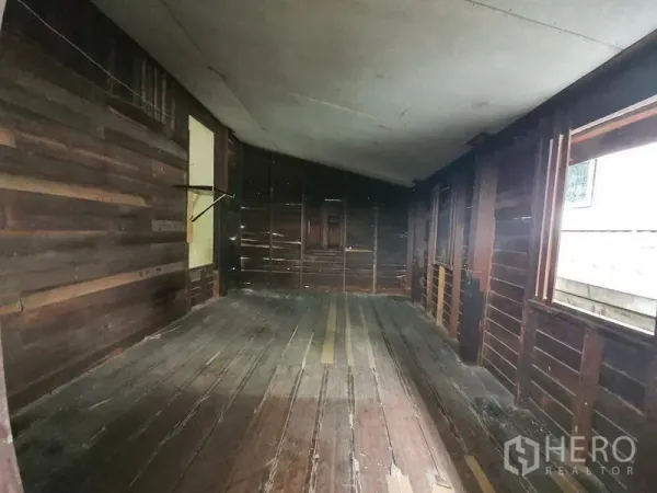Detached House for rent in Sathon, Bangkok - Long wooden room with plank flooring, exposed timber walls and side windows.