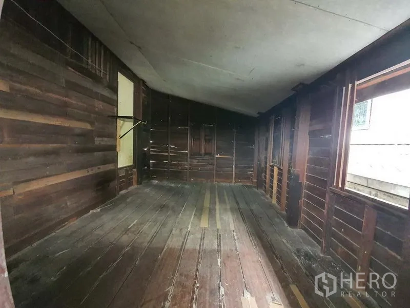 Detached House for rent in Sathon, Bangkok - Long wooden room with plank flooring, exposed timber walls and side windows.