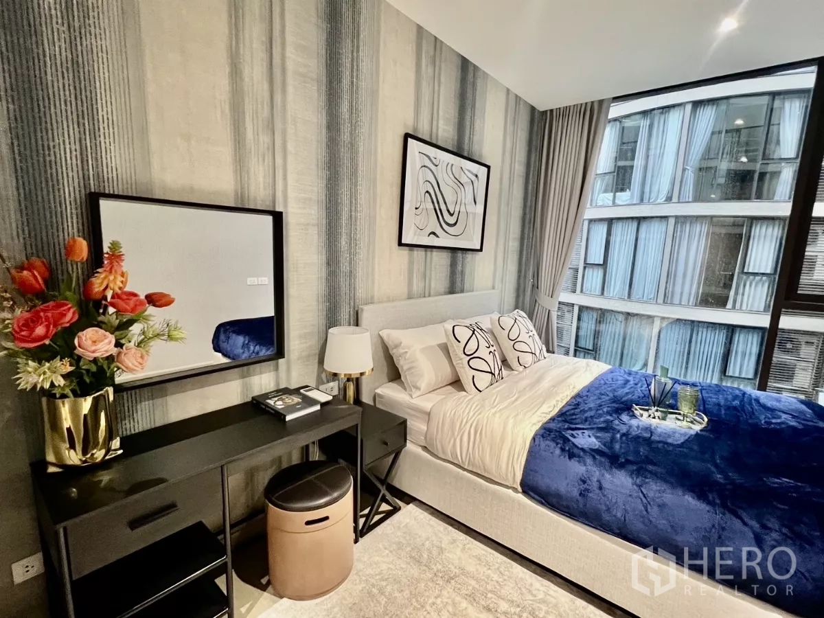 Condominium for rent in Khlong Toei, Bangkok - Bright bedroom with console table, bedside lamp and curtain wall.