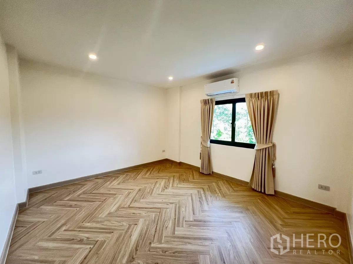 Detached House for rent in Suan Luang, Bangkok - Third bedroom unfurnished with herringbone flooring and garden outlook.