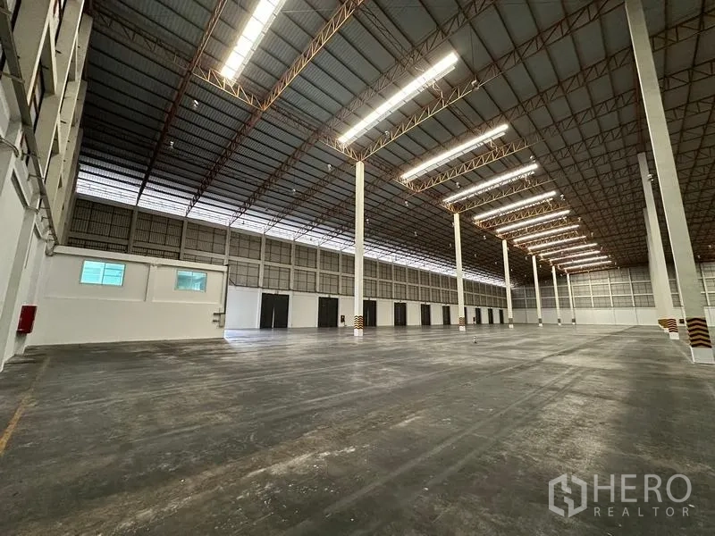 Warehouse for rent in Phra Nakhon Si Ayutthaya - High-ceiling warehouse with rows of columns and polished concrete floor.