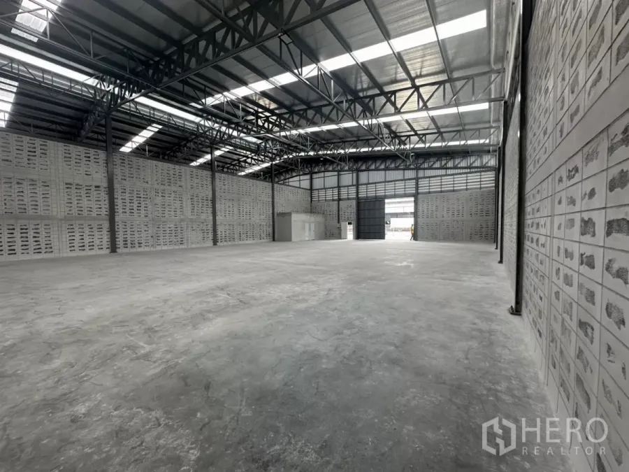 Warehouse for rent in Khlong Toei, Bangkok - Spacious warehouse interior with high steel truss roof, skylights and smooth concrete floor.