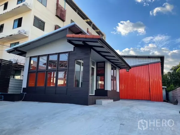 Warehouse for rent in Khlong Toei, Bangkok - Corner view of the office pavilion and red warehouse facade over a spacious loading yard.