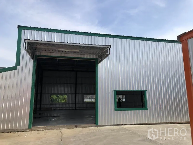 Warehouse for rent in Don Mueang, Bangkok - Front facade of the warehouse featuring a large roller shutter door and concrete apron.