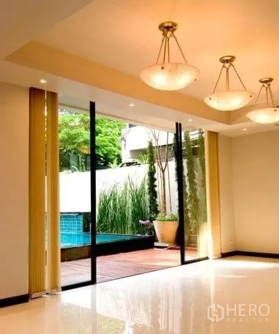บ้าน ให้เช่าในKhlong Toei, Bangkok - ห้องนั่งเล่นสว่าง เปิดสู่ดาดไม้และสระด้วยประตูกระจกเลื่อน