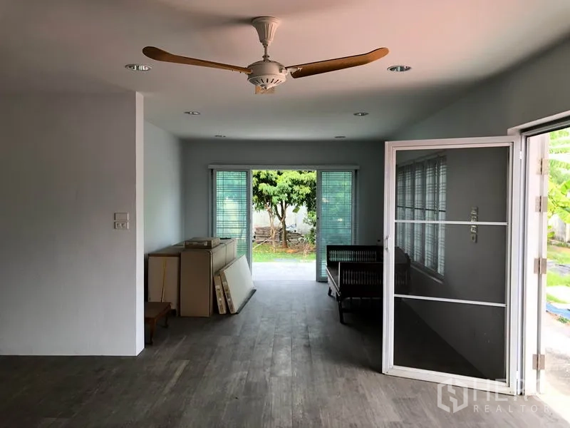 Detached House for sale in Bang Khen, Bangkok - Living and dining space with screen doors, ceiling fan and view toward the rear yard and side rooms.