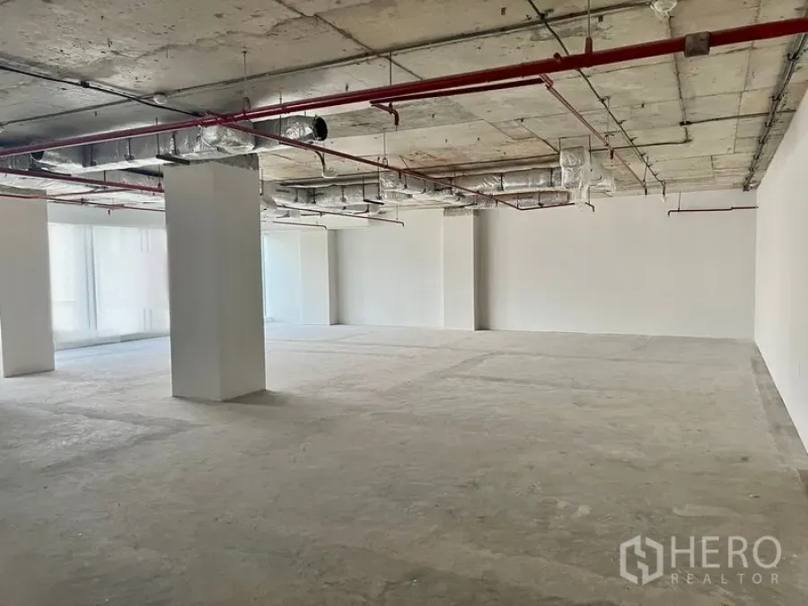 办公空间 出租在Sathon, Bangkok - 开放式Shell & Core写字楼楼层，裸露天花管线与红色喷淋，混凝土地面和白色立柱，位于曼谷沙吞。