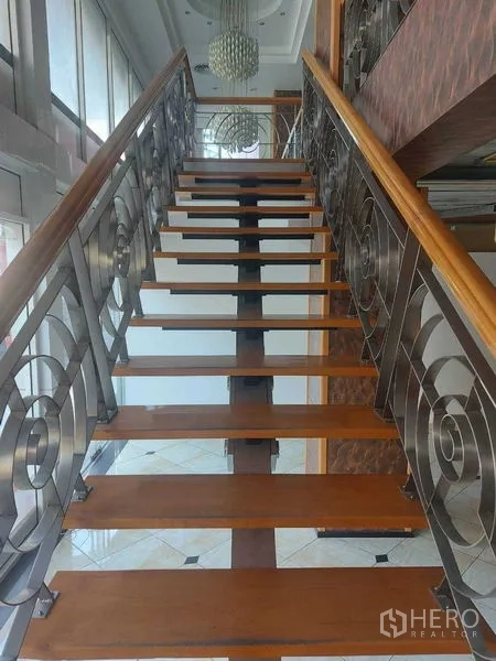 Retail Space for rent in Pathum Wan, Bangkok - Wood and metal staircase with decorative railings and a chandelier overhead.