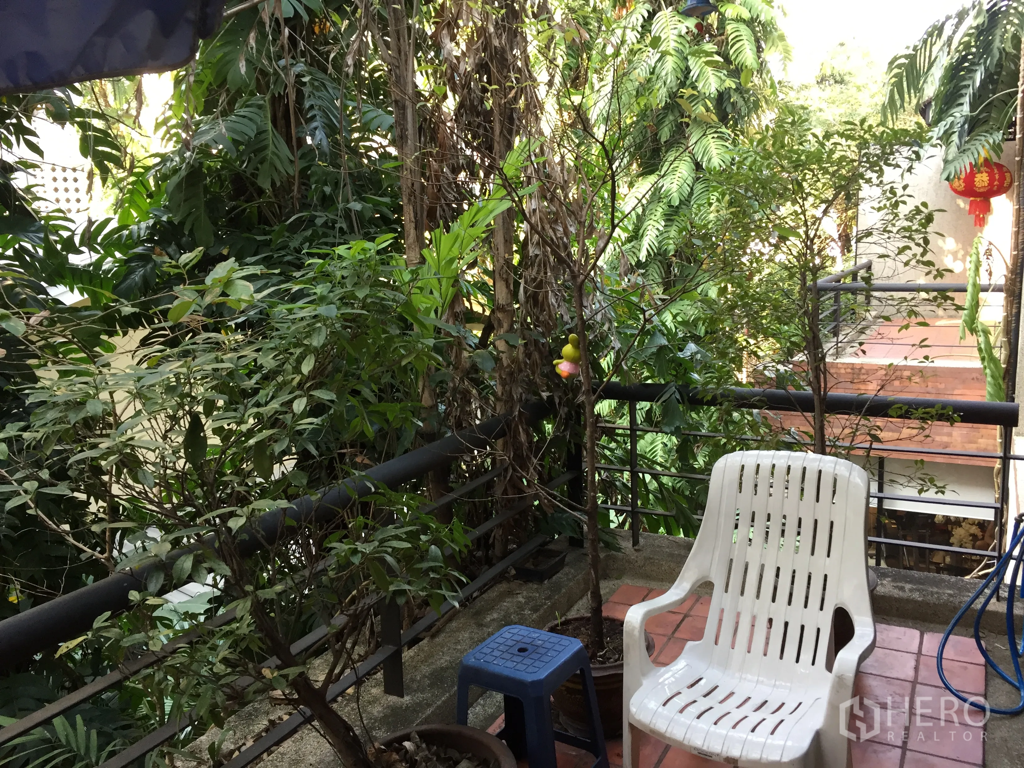 联排别墅 出租在Watthana, Bangkok - 被绿植环绕的上层阳台，配休闲椅与栏杆