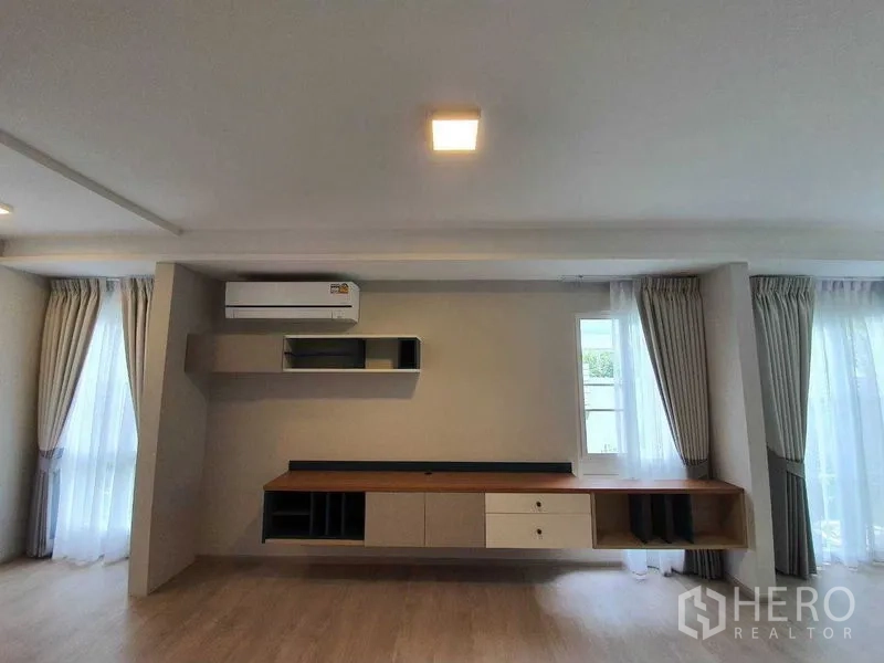 Townhouse for rent - Built-in media console wall with shelving and air conditioner in the living area.
