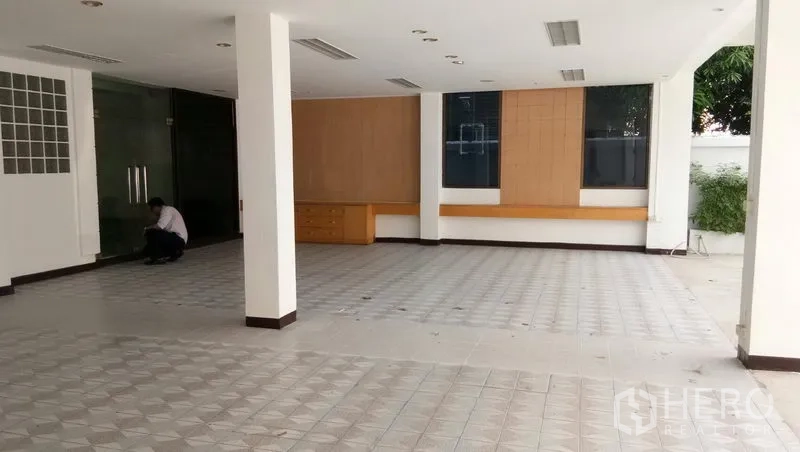 Office Space for rent in Sathon, Bangkok - Bright open workspace with large windows, wood wall panels, and tile floor.