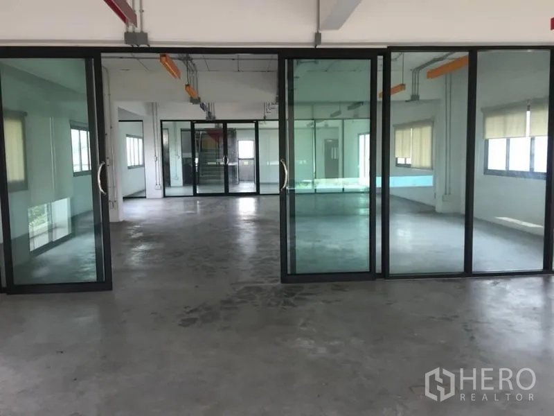 Home Office for rent or sale in Wang Thonglang, Bangkok - Open-plan office floor with sliding glass partitions, polished concrete and exposed ceiling conduits.