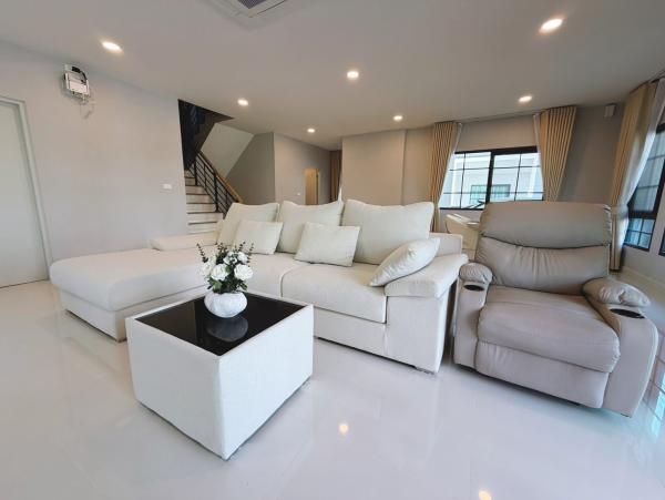 Detached House for rent in Bang Phli, Samut Prakan - Bright living room with large sectional sofa, recliner, staircase and multiple windows.