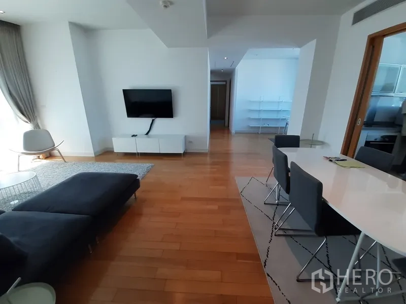 Condominium for rent in Khlong Toei, Bangkok - Spacious living and dining zone with TV console and wide hallway on wooden flooring.