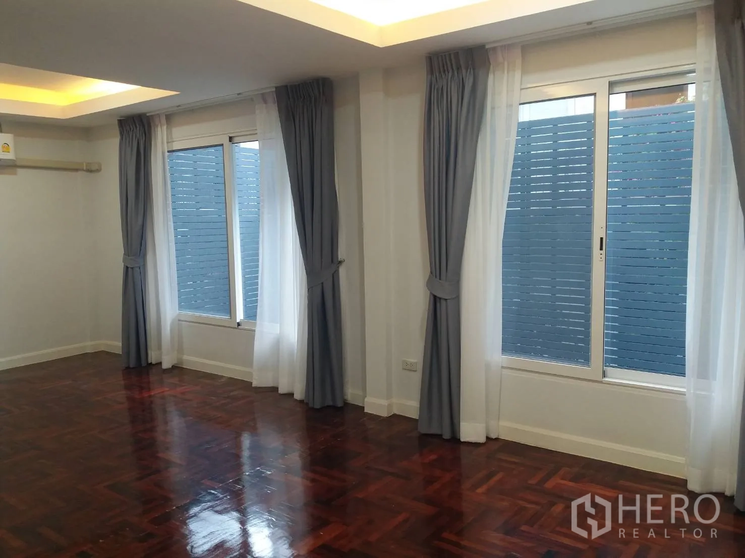 Townhouse for rent in Khlong Toei, Bangkok - Bedroom with glossy parquet floors, sliding windows, privacy screens and drapes.