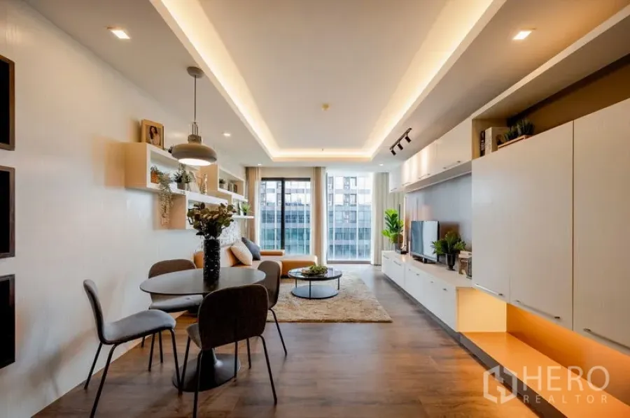 Condominium for sale in Khlong Toei, Bangkok - Another view of the dining and living room with cove lighting and balcony windows.