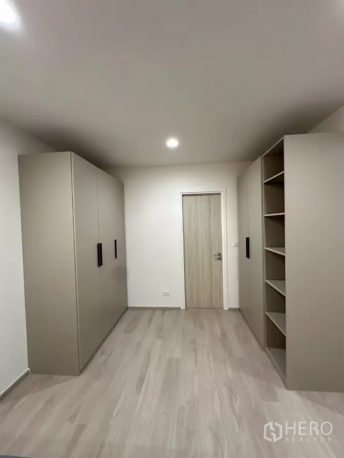 Townhouse for rent in Saphan Sung, Bangkok - Walk-in wardrobe corridor with multiple built-in closets and open shelving.